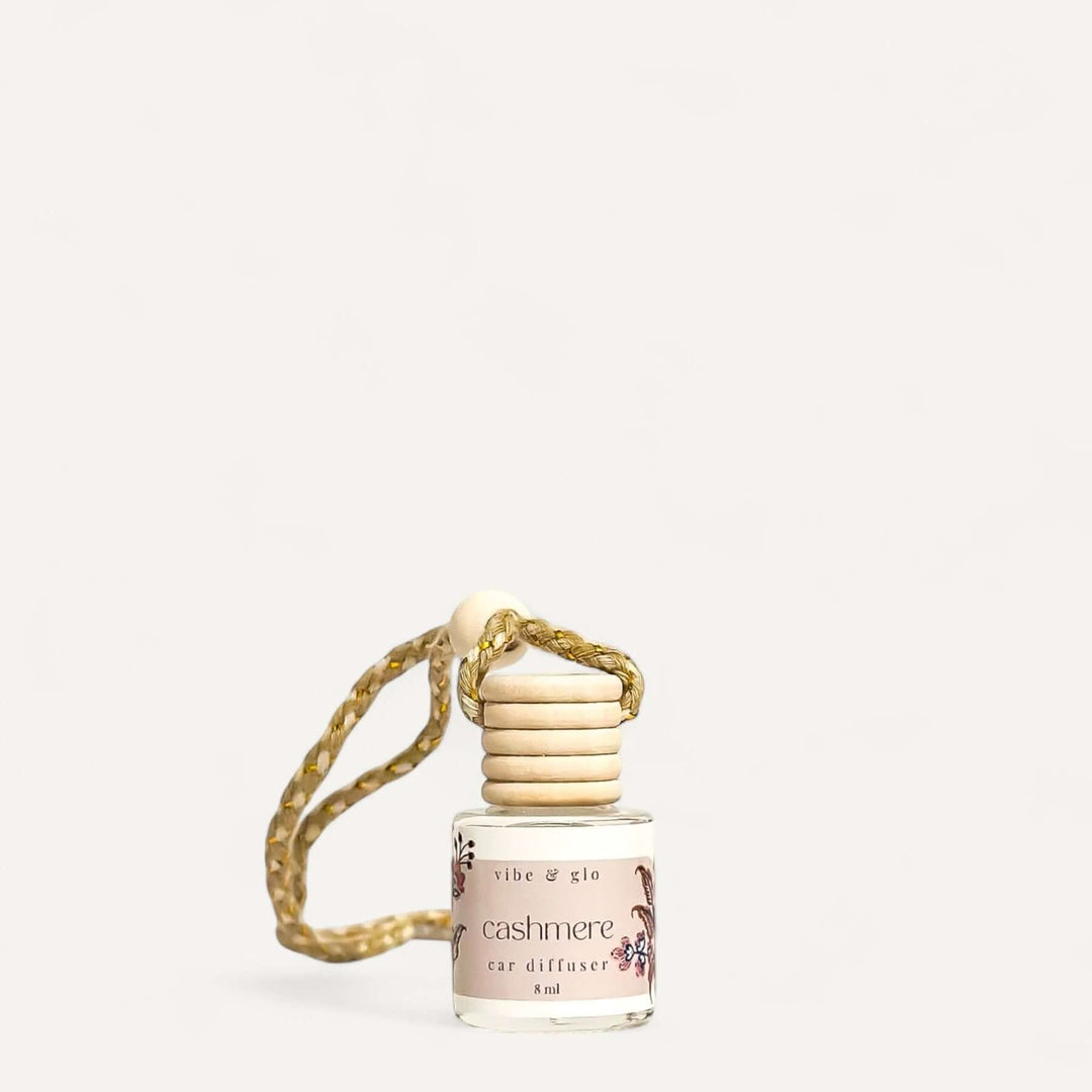 Refillable cashmere car air diffuser with elegant glass bottle and decorative hanging string.