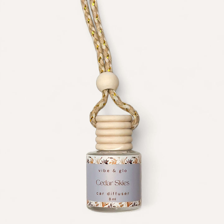 Cedar Skies car diffuser by Vibe & Glo, featuring a wooden top and a braided cord for autumn scents in your vehicle.