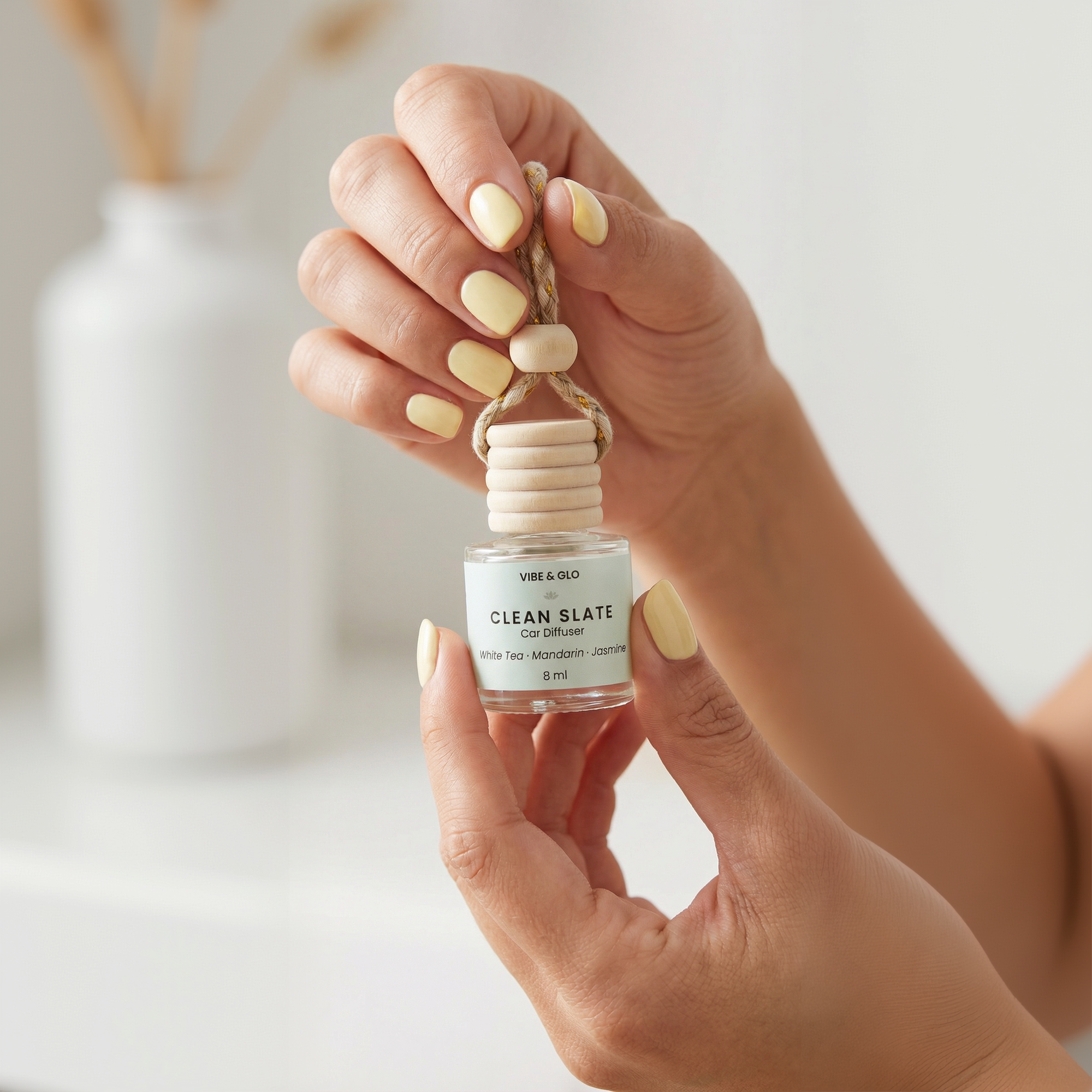 Hand holding a 'Clean Slate' car diffuser against a neutral background