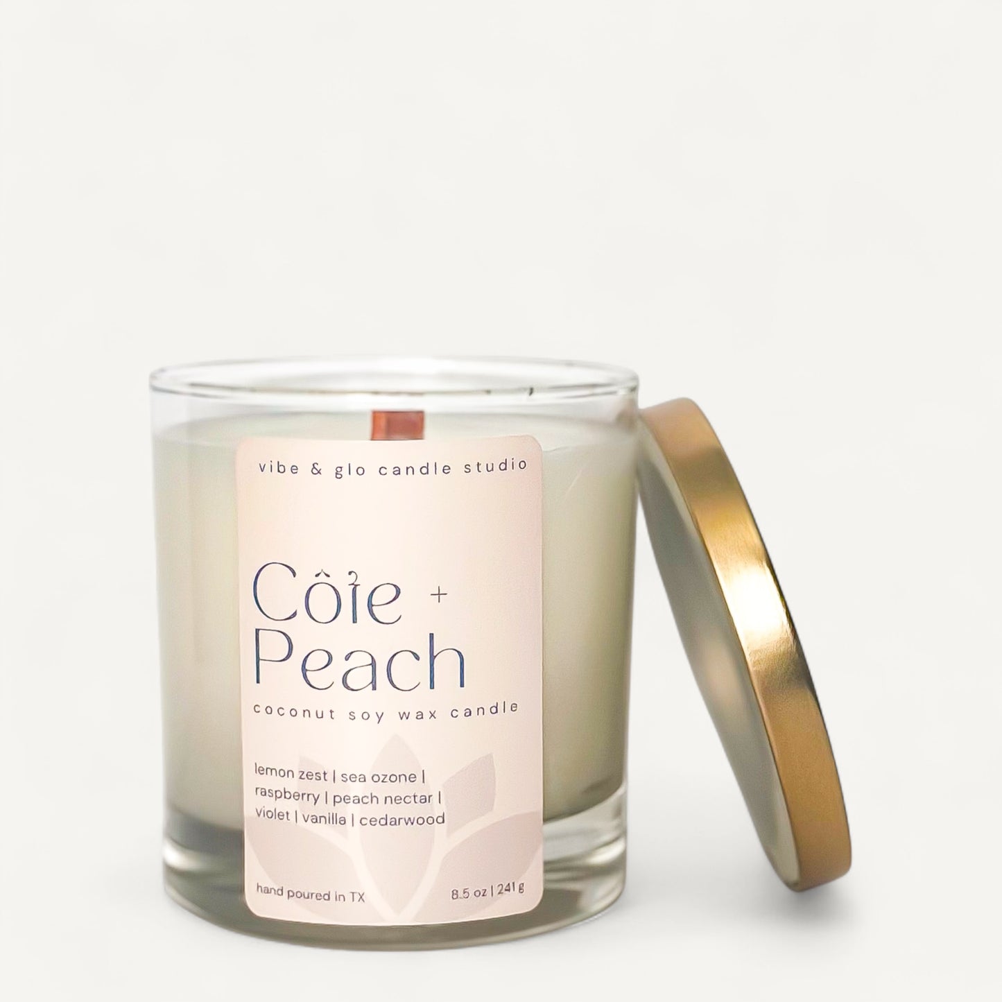 Côte + Peach coconut soy wax candle in glass jar with gold lid, featuring lemon zest and peach nectar scents.