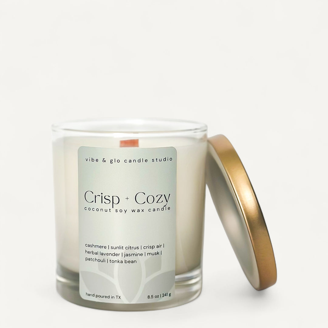 Crisp + Cozy candle with gold lid and green label on a white background
