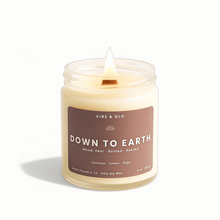 Candle in a jar labeled 'Down to Earth' by Vibe & Glo on a white background