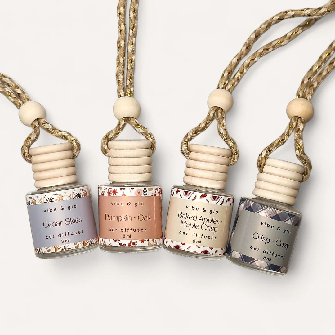 Fall Car Diffuser Bundle featuring Cedar Skies, Pumpkin Ok, Baked Apples Maple Crisp, and Crisp + Cozy scent bottles.