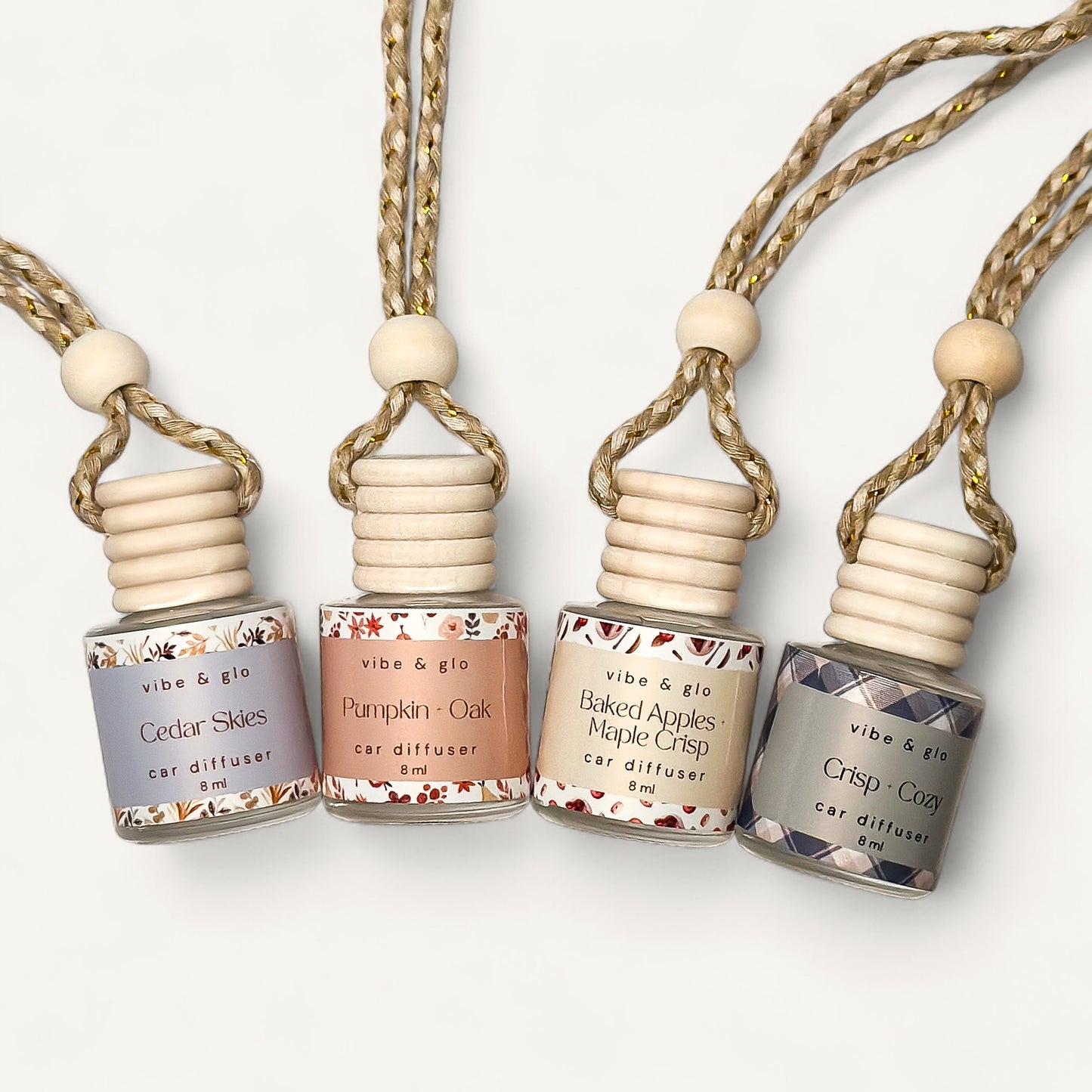 Fall Car Diffuser Bundle featuring Cedar Skies, Pumpkin Ok, Baked Apples Maple Crisp, and Crisp + Cozy scent bottles.