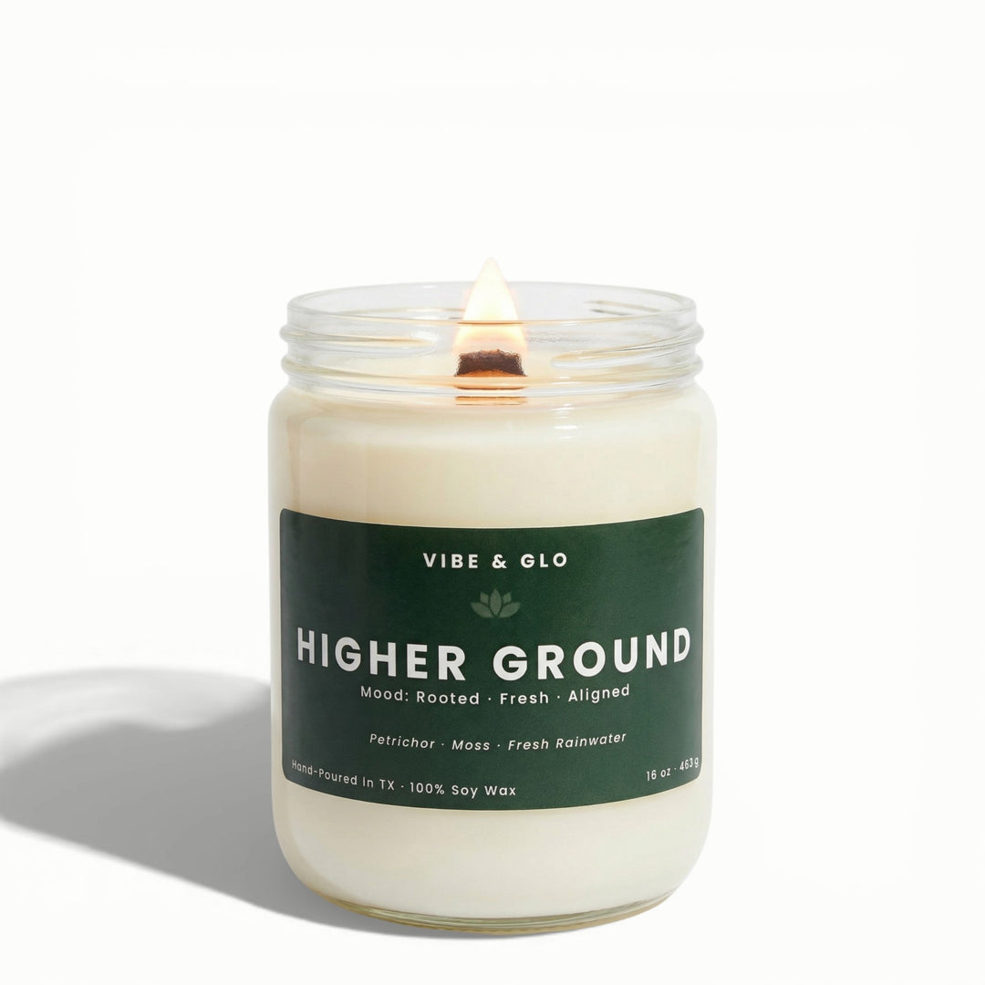 Higher Ground 16 oz wooden wick soy candle by Vibe & Glo with petrichor, moss, and fresh rainwater, lit wooden wick, centered front-facing studio product image.