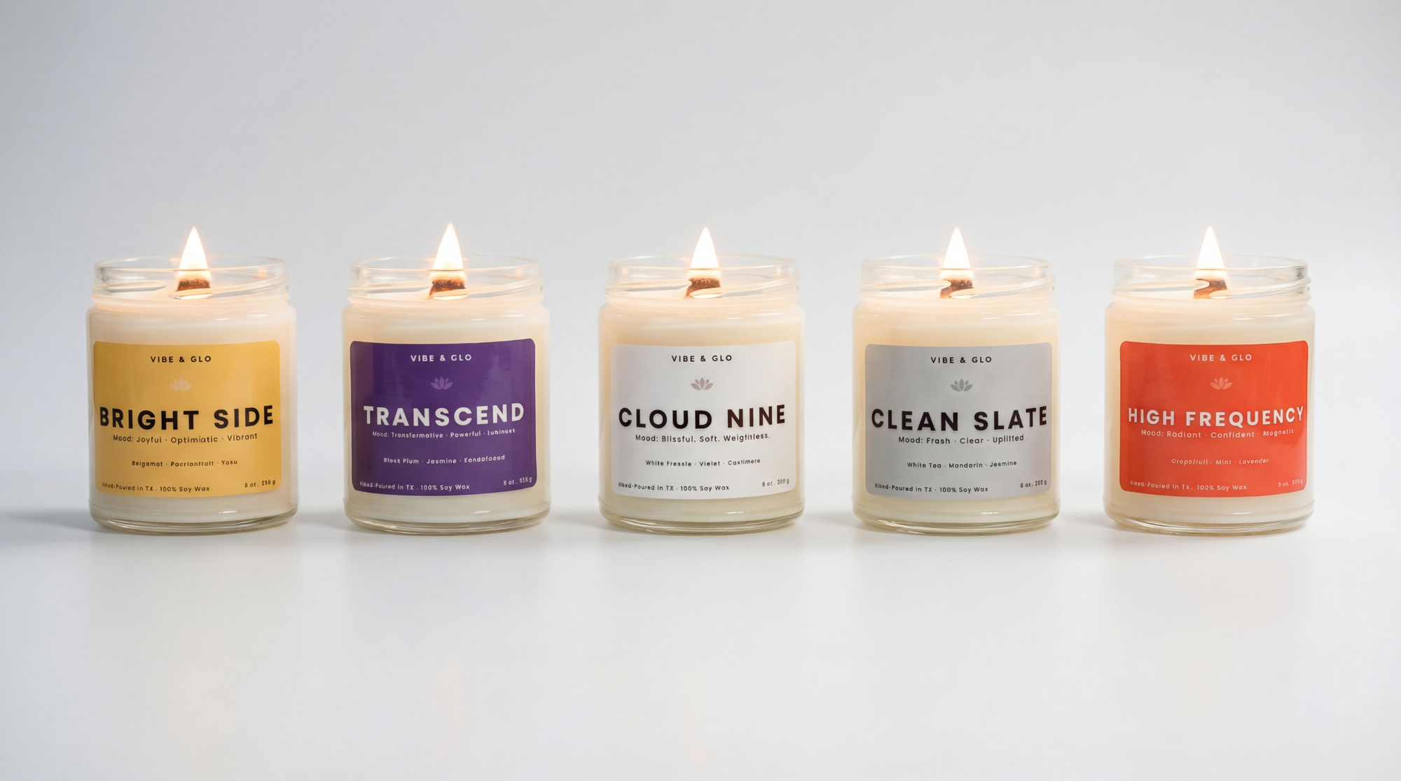 Vibe & Glo mood candle collection with Bright Side, Transcend, Cloud Nine, Clean Slate, and High Frequency soy candles with wooden wicks burning in glass jars on a white background