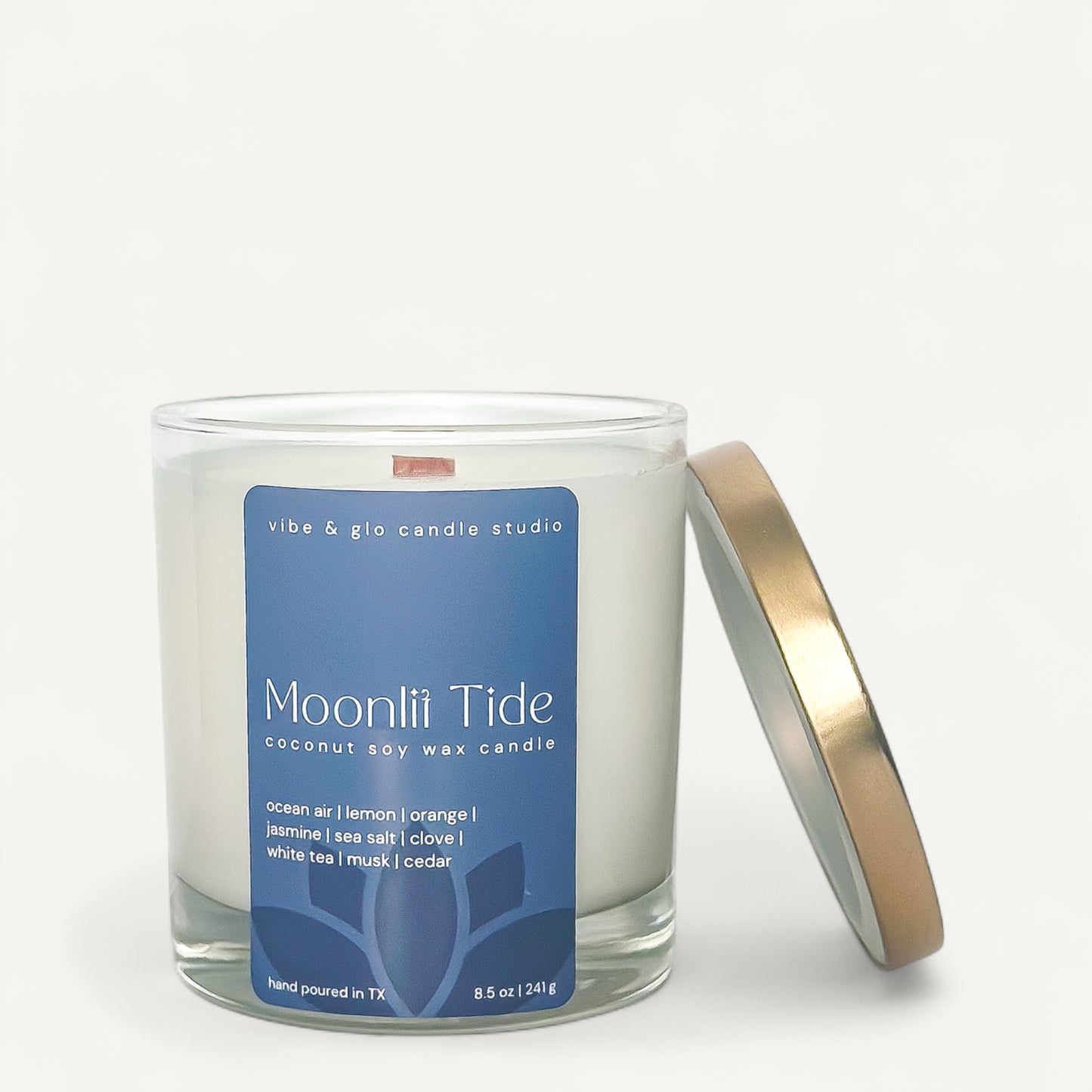 Moonlit Tide wood wick candle in glass jar, featuring ocean air, citrus, and jasmine scents.