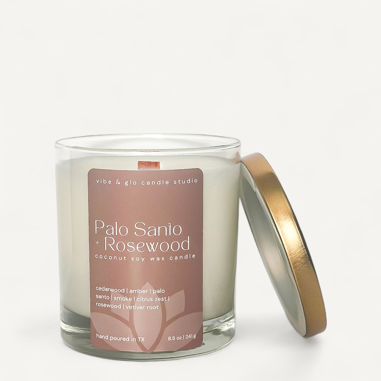 Palo Santo + Rosewood candle in glass jar with gold lid, featuring a soothing coconut soy wax blend.
