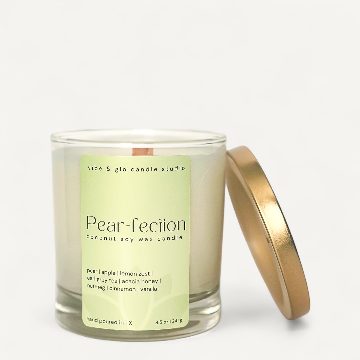 Pear-fection coconut soy wax candle with pear and apple scent in a glass jar with a gold lid.