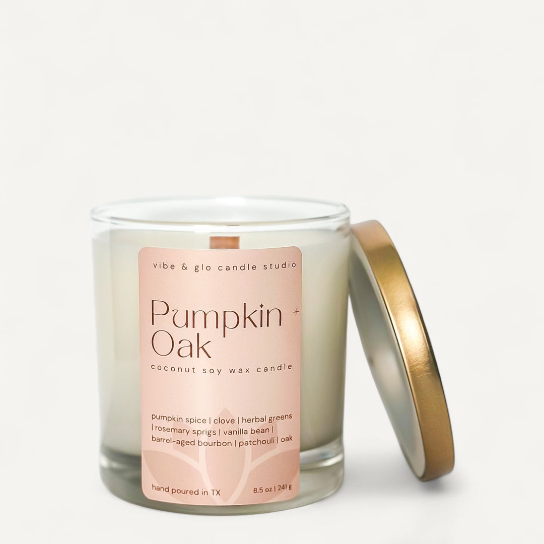 Pumpkin + Oak candle by Vibe & Glo with a light orange label on a white background