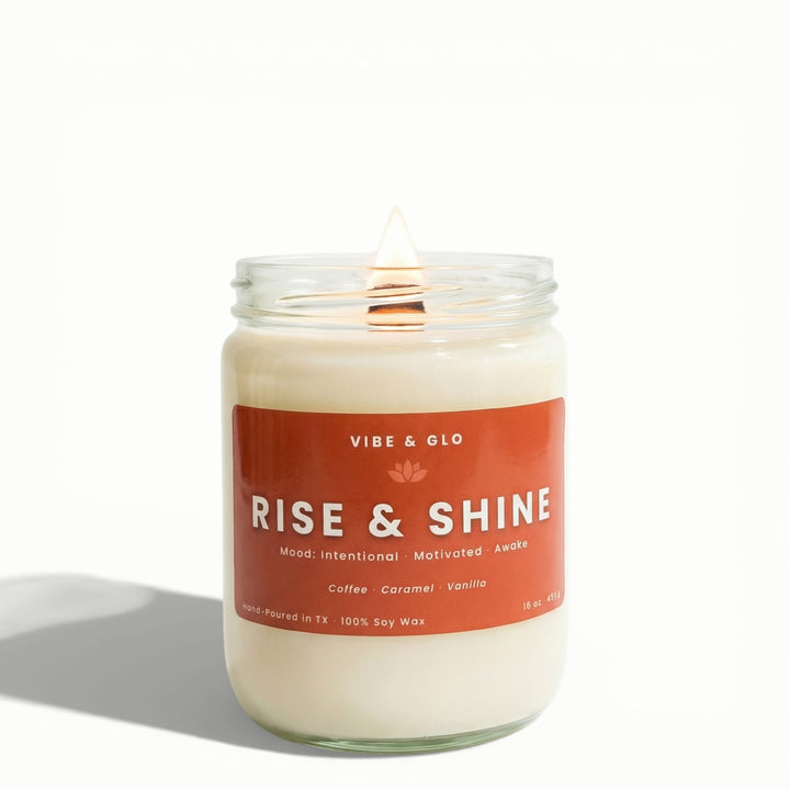 Rise & Shine 16 oz wooden wick soy candle by Vibe & Glo with coffee, caramel, and vanilla, lit wooden wick in clear glass jar, front-facing studio image with soft shadow.