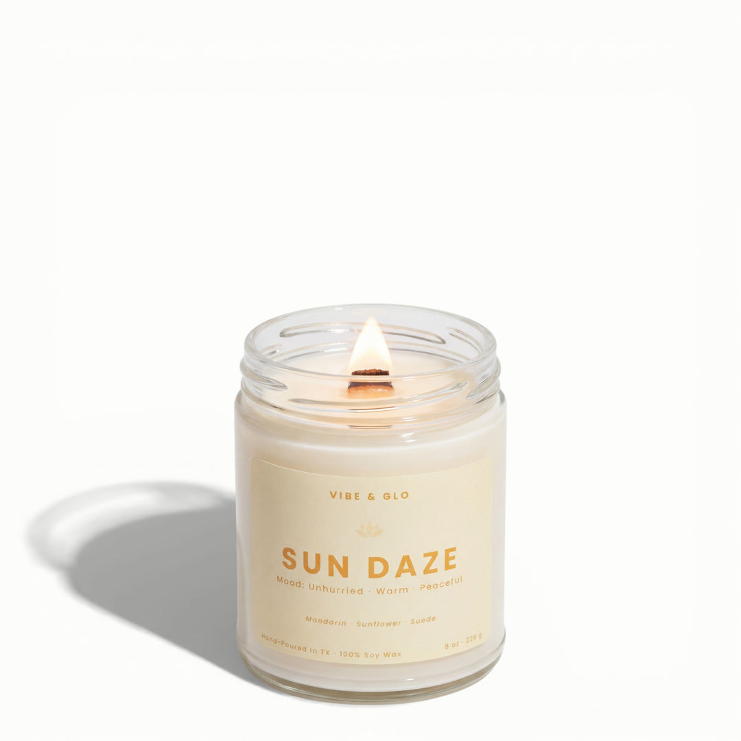 Sun Daze wooden wick soy candle by Vibe & Glo with mandarin, sunflower, and suede in clear 8 oz glass jar on white background.