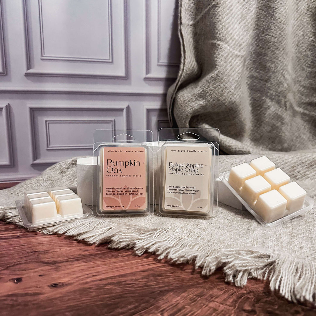 Wax melts in packaging on a wooden surface with a blanket in the background