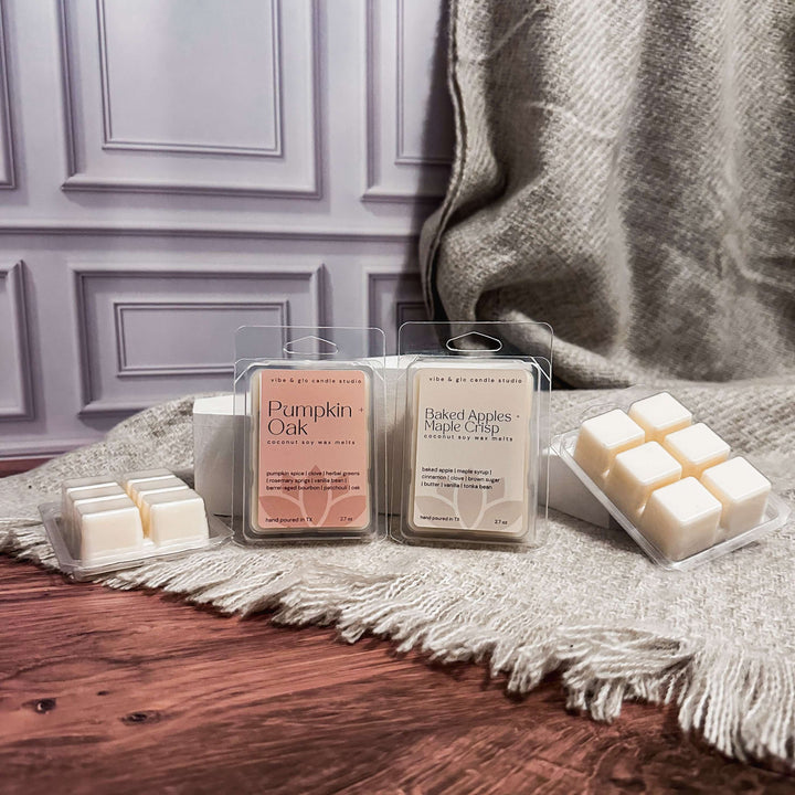Wax melts in packaging on a wooden surface with a blanket in the background