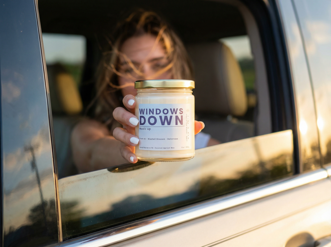 Windows Down candle by Vibe & Glo held out of a car window at golden hour, capturing a carefree, fresh air lifestyle moment for Vibe of the Month Candle Subscription Box.